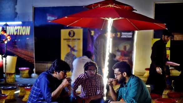 Pakistanis gather to drink tandoori tea in clay pots in Islamabad. [Farooq Naeem/AFP]