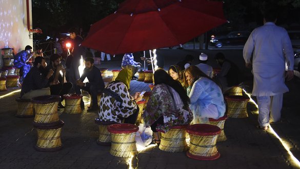 اسلام آباد میں پاکستانی شہری، مٹی کے برتنوں میں تندوری چائے پینے کے لیے اکٹھے ہوئے ہیں۔ [فاروق نعیم/ اے ایف پی]