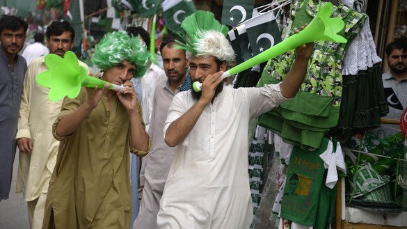 Young men in Peshawar blow bugles as Independence Day nears. [Shahbaz Butt]