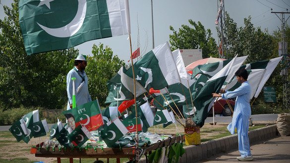 ایک گاہک، 10 اگست کو پشاور میں سڑک کے کنارے لگائے گئے ٹھیلے سے قومی جھنڈا منتخب کر رہا ہے۔ [شہباز بٹ]