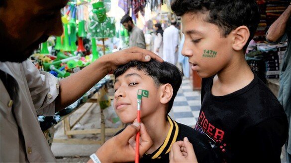 پشاور کے قصہ خوانی بازار میں بچوں نے اپنے چہروں پر پاکستانی جھنڈے بنا رکھے ہیں۔ [شہباز بٹ]