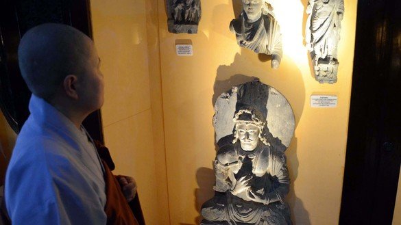 A South Korean monk August 26 views sculptures of Buddha displayed at the Peshawar Museum. [Adeel Saeed]