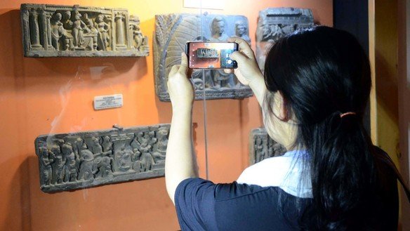 A member of an expedition team of South Koreans visiting Khyber Pakhtunkhwa photographs Buddhist relics at the Peshawar Museum. [Adeel Saeed]