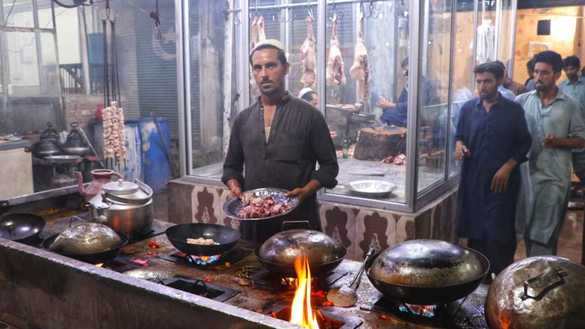 ریستوران کا ایک ملازم یکم ستمبر کو پشاور میں تکہ کڑاہی بنا رہا ہے۔ [عالمگیر خان]