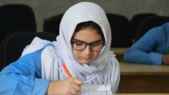 A student works on an assignment at the Mohmand Model School on December 5. [Alamgir Khan]