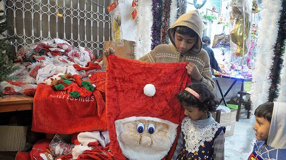 Children select a bag meant to hold Christmas presents at St. John's Cathedral in Peshawar. [Shahbaz Butt]