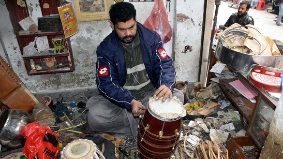 An artisan in Peshawar repairs a hand drum December 20. [Adeel Saeed]