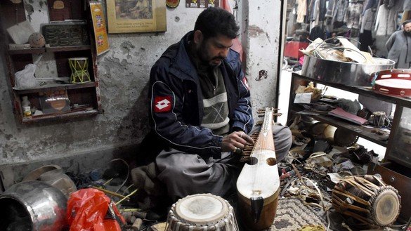 An artisan in Peshawar makes a rabab on December 20. [Adeel Saeed]
