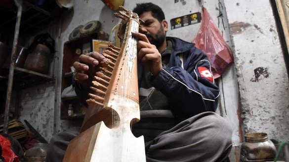 An artisan in Peshawar fixes a rabab on December 20. [Adeel Saeed]