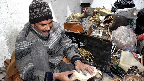 An artisan in Peshawar fixes musical instruments on December 20. [Adeel Saeed]