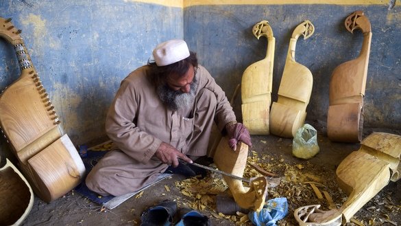 In this picture taken on December 10, a worker makes a traditional rabab musical instrument in a workplace on the outskirts of Peshawar. [Abdul MAJEED / AFP]