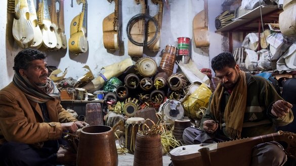 3 دسمبر کو لی گئی اس تصویر میں پشاور کے نواح میں ایک کارخانے میں کارکنان روائتی آلاتِ موسیقی رباب بنا رہے ہیں۔ [عبدالمجید /اے ایف پی]