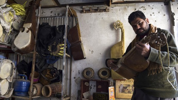 3 دسمبر کو پشاور کے نواح میں ایک کارخانے میں ایک کارکن ایک روایتی آلہٴ موسیقی رباب کو جانچ رہا ہے۔ [عبدالمجید /اے ایف پی]
