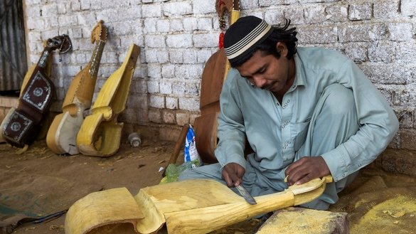 10 دسمبر کو لی گئی اس تصویر میں ایک کارکن پشاور کے نواح میں ایک کارخانہ میں روایتی آلہٴ موسیقی رباب تیار کر رہا ہے۔ [عبدالمجید /اے ایف پی]