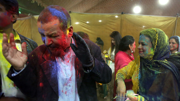 A woman in Peshawar throws colours on a man during Holi celebrations in Peshawar March 10. [Shahbaz Butt]