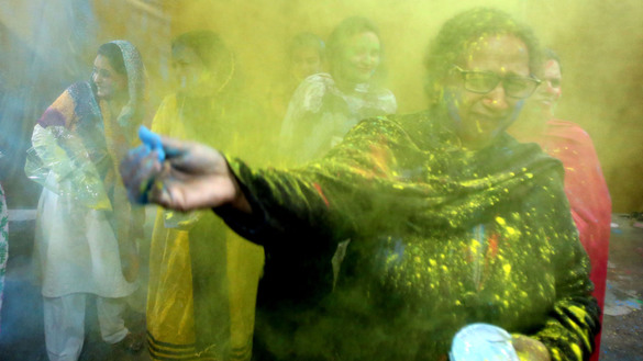 A woman in Peshawar March 10 throws colours during Holi celebrations. [Shahbaz Butt]