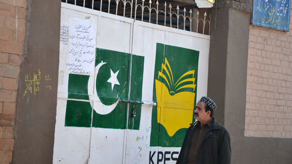 16 مارچ کو پشاور میں ایک سکول کے دروازے کے قریب کھڑا ایک شخص سکول بند ہونے کا نوٹس پڑھ رہا ہے۔ [شہزاد بٹ]
