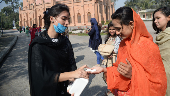 15 مارچ کو پشاور میں سینٹ جانز کیتھیڈرل میں ایک مسیحی رضاکار اتوار کی عبادت میں شریک خاندانوں میں دستی جراثیم کُش بانٹ رہا ہے۔ [شہزاد بٹ]