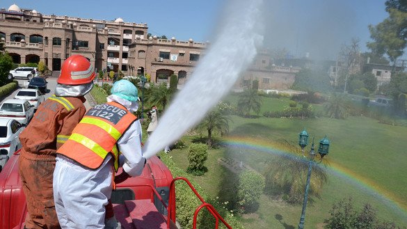 Personnel of Rescue 1122 spray disinfectant in different areas of Peshawar on March 22. [Shahbaz Butt]