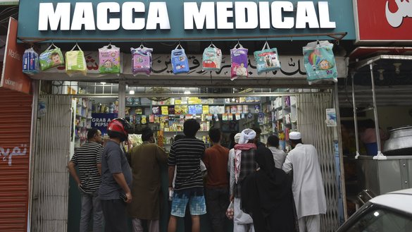 Customers line up at a pharmacy after the Sindh provincial government declared a lockdown on March 22. [Rizwan Tabassum/AFP]