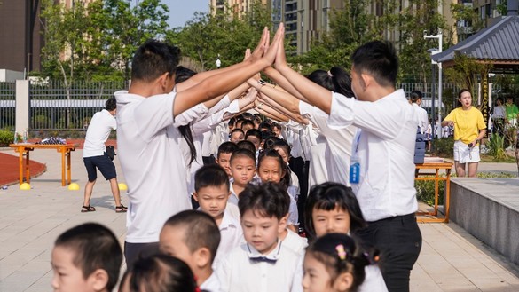 یکم ستمبر کو وُوہان، چین میں نئے سمیسٹر کے پہلے روز سکول آنے پر اساتذہ ایلیمنٹری سکول کے طلبہ کو خوش آمدید کہہ رہے ہیں۔ [ایس ٹی آر / اے ایف پی]