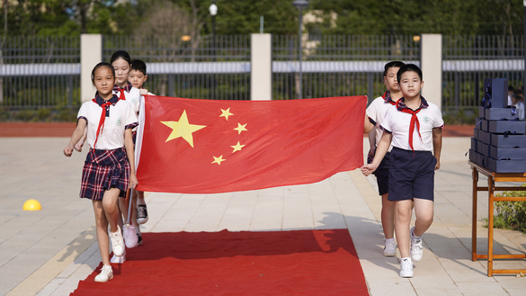 یکم ستمبر کو وُوہان، چین میں پرچم کشائی کی ایک تقریب کے دوران ایلیمنٹری سکول کے طلبہ ایک قومی پرچم اٹھائے ہوئے ہیں۔ [ایس ٹی آر / اے ایف پی]