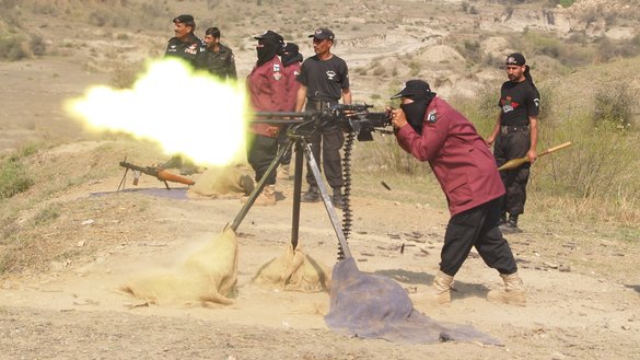 A female commando fires a heavy machine gun during training in Nowshera in October. [Javed Khan]