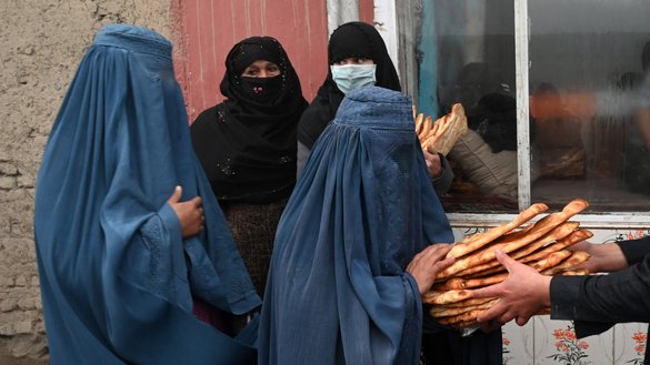 افغانوں کو بھوک سے بچاؤ مہم کے جزو کے طور پر، 18 جنوری کو کابل میں خواتین ایک بیکری کے سامنے تقسیم کی گئی مفت روٹی لیتے ہوئے۔ [وکیل کوہسار/اے ایف پی]