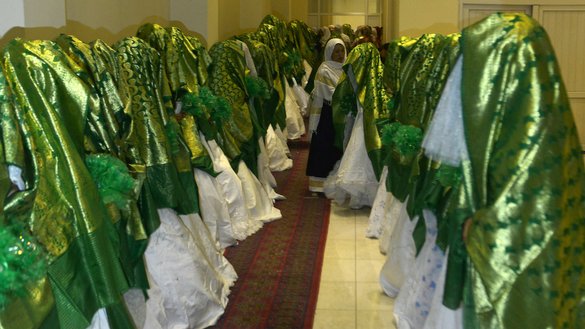 Brides stand inside a wedding hall as they wait for the start of a mass marriage ceremony in Kabul on June 13. [Sahel Arman/AFP]