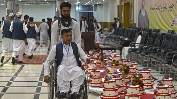 کابل میں 13 جون کو ہونے والی اجتماعی شادی کی تقریب کے دوران، وہیل چیئر پر ایک دولہا شادی ہال کے اندر آ رہا ہے۔ [سہیل ارمان/اے ایف پی]