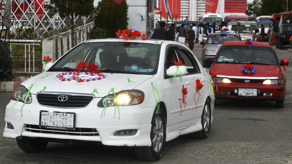 Decorated cars carrying Afghan couples leave the wedding hall after a mass marriage ceremony in Kabul on June 13. [Sahel Arman/AFP]