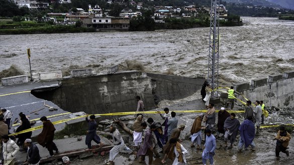 پاکستانی شہری 27 اگست کو وادی سوات کے مدیان کے علاقے میں شدید مون سون بارشوں کے بعد، سیلابی پانی سے تباہ ہونے والی سڑک کے سامنے جمع ہیں۔ [عبدالمجید/اے ایف پی]