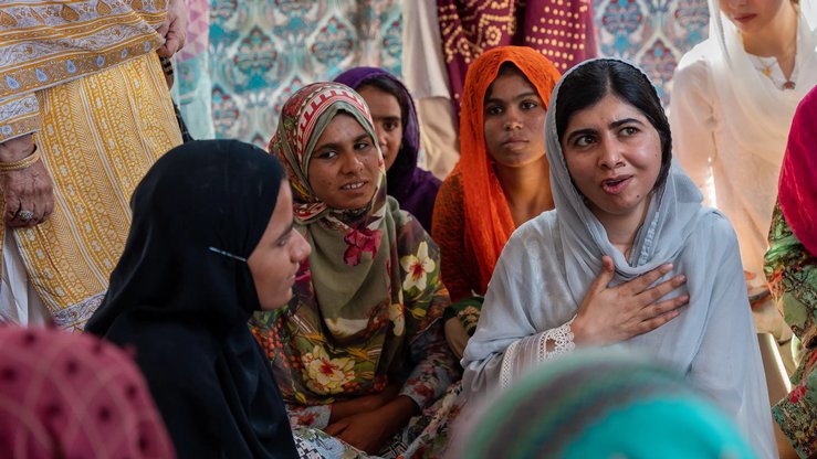 Malala returns home, pledges to help flood victims