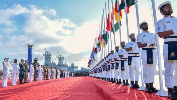 Officers from various navies salute their flags during the flag raising ceremony of the AMAN-23 drill in Karachi on February 10. [Pakistan Navy)
